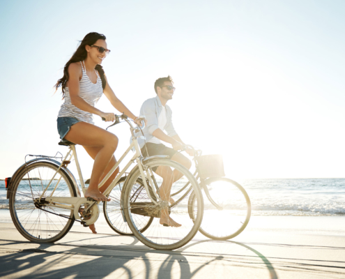 couple riding bikes on beach