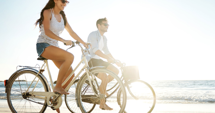 couple riding bikes on beach